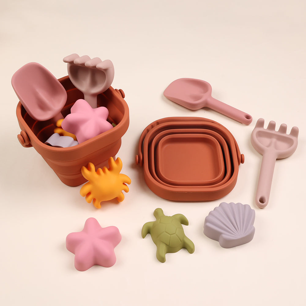 Kids playing with foldable silicone beach bucket set NZ — Te Rā