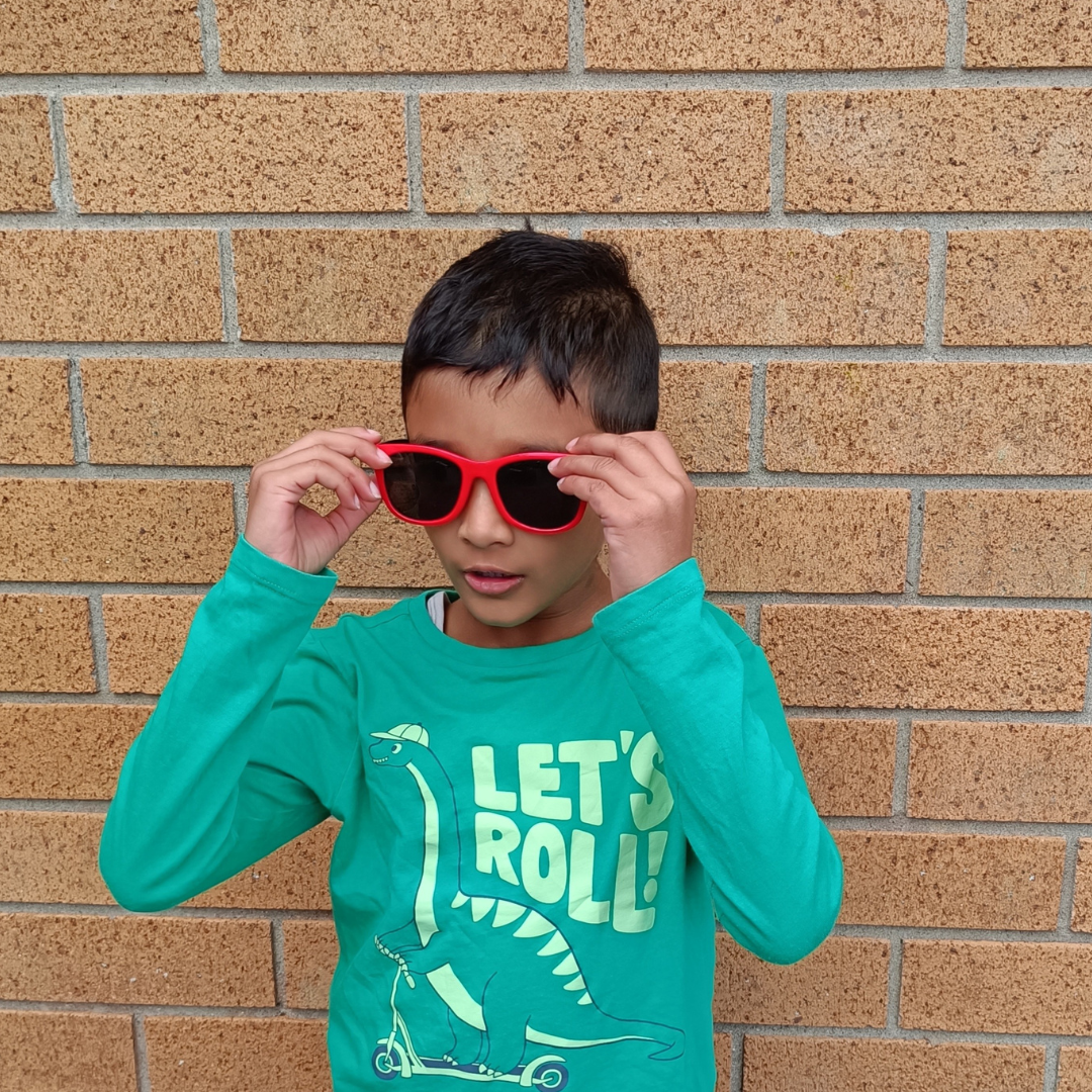 Child wearing Wai Classic Red Black kids sunglasses NZ — Te Rā